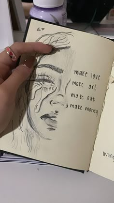 a person is holding an open book with drawings on it and writing in the pages