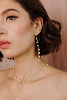 Add a touch of graceful elegance to your bridal look with the Whispering Pearl Drop Earrings! These stunning dangle earrings feature freshwater pearls delicately hanging from a fine gold chain, creating a perfect balance of timeless beauty and modern sophistication. Why do we love them? They’re the perfect blend of chic and classic beauty, making them a must-have for your special day! EARRING FEATURES Material: Brass, Freshwater Pearls Dimensions/Size: 3.2" drop Finish: Polished 14k Gold Plating