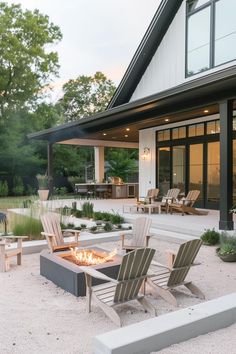 a fire pit in the middle of a gravel area with chairs and tables around it