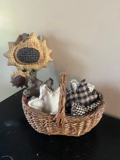 a wicker basket filled with stuffed animals sitting on top of a black table next to a wall