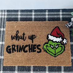 a door mat that says, what up grinies? with an image of the grin on it