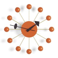 an orange clock with arrows and balls on the face is shown against a white background