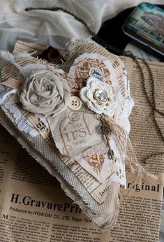 an altered piece of fabric with flowers on it sitting on top of a newspaper page