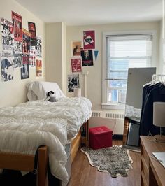 a bed room with a neatly made bed and lots of pictures on the wall above it