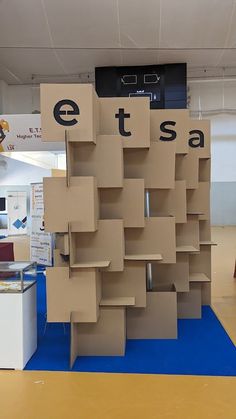 cardboard boxes are stacked on top of each other in the middle of a room with blue flooring