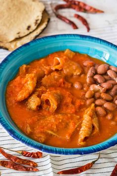 a blue bowl filled with beans and meat