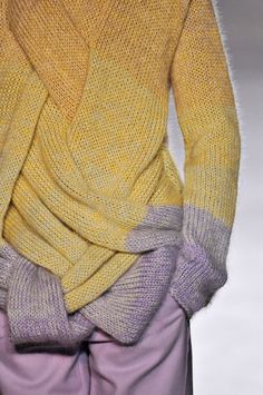 a yellow sweater and purple pants on the runway