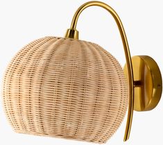 a light that is on the wall next to a basket holder with a gold handle