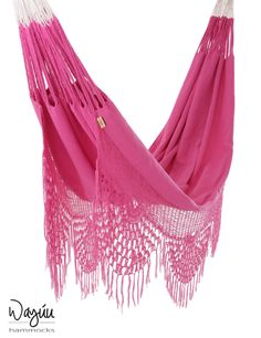 a pink hammock with fringes hanging from it's side on a white background