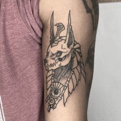 a man's arm with a tattoo on it that has a skull and horns