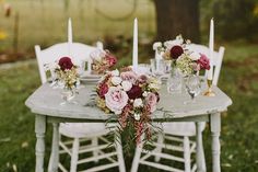 the table is set with flowers and candles