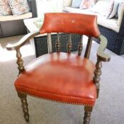 a red leather chair sitting on top of a carpeted floor