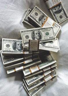 a pile of money sitting on top of a bed