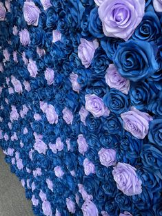 blue and purple flowers are arranged on the wall