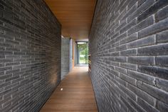 an empty hallway between two brick buildings with wood flooring and wooden walls on either side