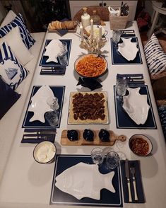 a table set with plates, bowls and utensils