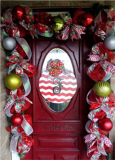 a red door decorated with christmas decorations and ornaments on the front, and an american flag wreath