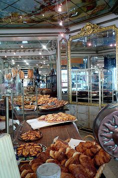 there are many baked goods on display in the store, including breads and pastries