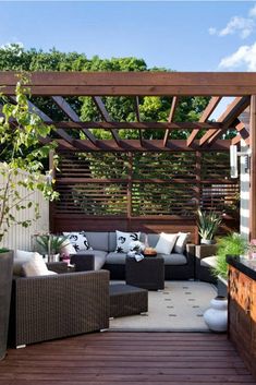 an outdoor living area with couches, tables and potted plants on the deck