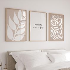 three framed pictures hang above a bed with white sheets and pillows on the headboard