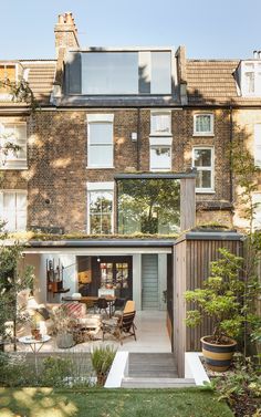 an apartment building with lots of windows and plants in the yard