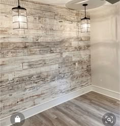 an empty room with wood paneling on the wall and ceiling fans hanging from the ceiling