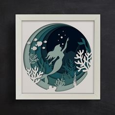 an image of a paper cut mermaid under the sea with fish and corals on it