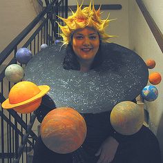 a woman wearing a costume made to look like the solar system with planets around her