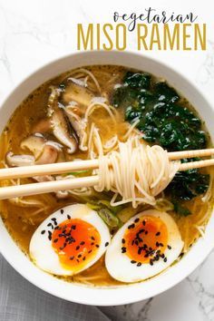 a bowl of miso ramen with two hard boiled eggs and spinach on top