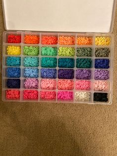 a box filled with lots of different colors of beads and sprinkles in it