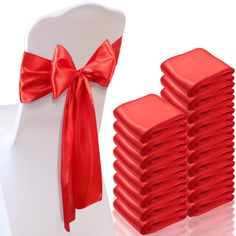 a stack of red napkins sitting on top of a white chair with a bow