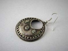 "Antique ethnic hook shaped silver earring. Antique mixed silver earring decorated with handcrafted granulation along the edges and close to the central hole. The silver is not sterling but the materials are in a very good quality. Nice antique earring. The hook is made in silver. Period: first half of 20th century. Provenience: Afghanistan. Dim. Full length: 1.85 inch. Weight: 3.4 grams CAD1. Back to \"Earrings\" section: https://www.etsy.com/shop/ArteOrientaleBologna?ref=l2-shopheader-name§ion Jewelry Hoop Earrings, Afghan Jewelry, Ethnic Earrings, Antique Earrings, Ethnic Jewelry, Silver Earring, Jewelry Earrings Hoops, Boho Earrings, Boho Jewelry