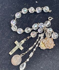 "This is a vintage crystal bead bracelet to which I have added - A vintage/antique French slide open two sided Saint Anne reliquary medal A vintage two sided Maximus medal A vintage crucifix vintage treat drop crystal 7 1/2\" (I can lengthen this bracelet if needed - at no charge. Just message me after purchase with desired length)" Vintage Silver Rosary With Round Beads, Vintage Rosary Bracelet With Round Beads As Gift, Vintage Beaded Crucifix Jewelry, Vintage Silver Handmade Rosary, Vintage Silver Rosary Bracelet As Gift, Handmade Silver Vintage Rosary, Handmade Vintage Silver Rosary, Vintage Cross Charms Jewelry, Vintage Adjustable Crucifix Jewelry