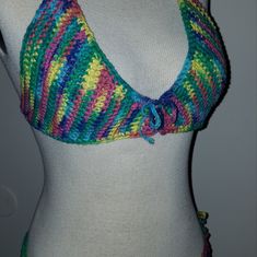 a woman wearing a multicolored crocheted halter top on a mannequin