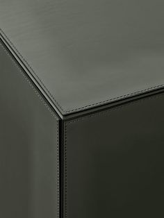 a close up view of the top of a black leather table with stitching on it