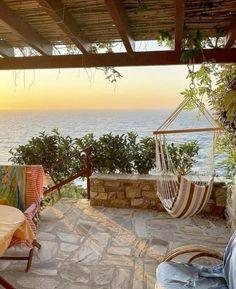 a hammock hanging from the side of a stone building next to an ocean