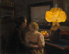 a woman and child sitting at a table with oranges in front of a lamp