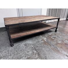 an industrial style coffee table with wheels on the bottom