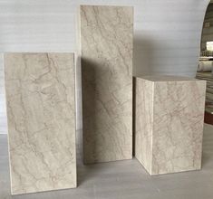 three marble blocks sitting next to each other in front of a mirror on the floor