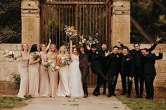 a group of people standing next to each other in front of a gate with flowers