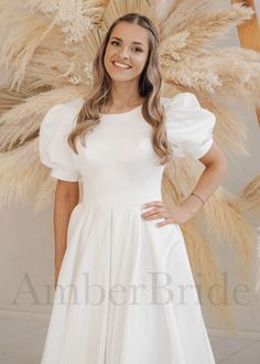 a woman in a white dress posing for the camera