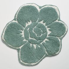 a green and white rug with a flower on it