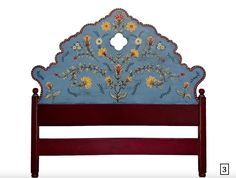 a blue headboard with flowers and leaves painted on the top, sitting against a white background