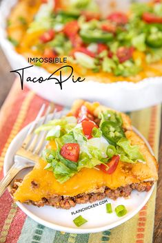 a piece of taco pie on a white plate with a fork and salad in the background