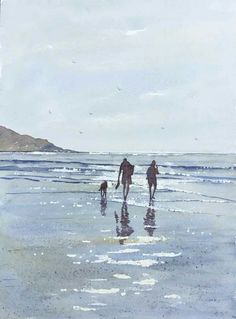 two people and a dog are walking on the beach