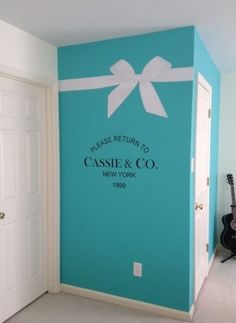 there is a blue wall with a white bow on it and the name casssin & co