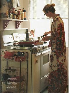 a woman standing in front of an oven cooking on top of a burner stove