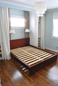 a bedroom with hardwood floors and white curtains