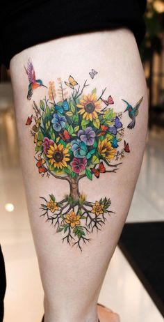 a woman's leg with flowers and butterflies on it in the shape of a tree