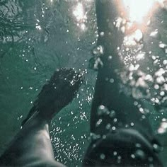 the feet of a person standing in water with sunlight shining through them and bubbles coming from their feet